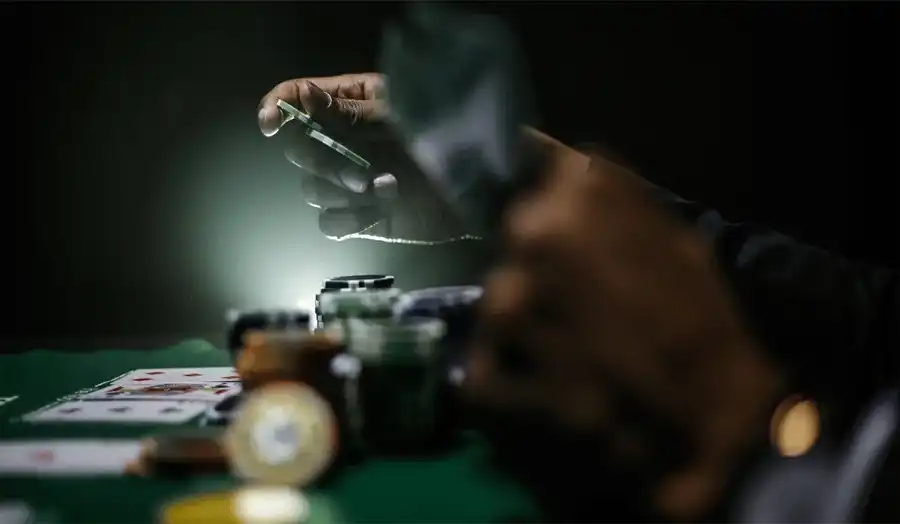 Baccarat player tracking card counts on a scorecard during gameplay