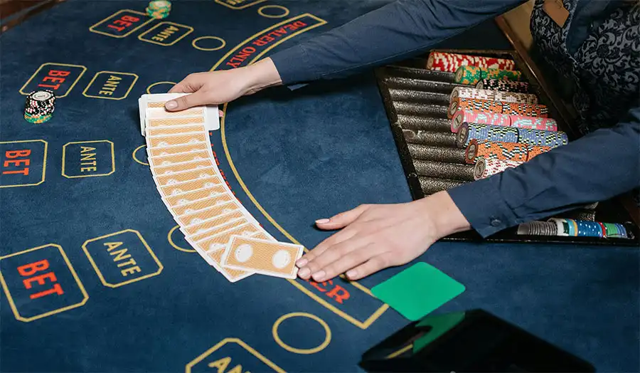 Dealer dealing baccarat cards on casino table during game