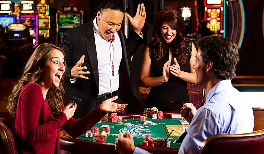 Baccarat player celebrating a winning hand at a casino table with cards and chips